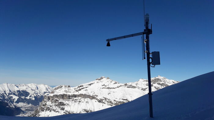 Klimaatstation op een alpentop: zonnepaneel, sonische windmeter, modembehuizing, solar-autonoom op grote hoogte.