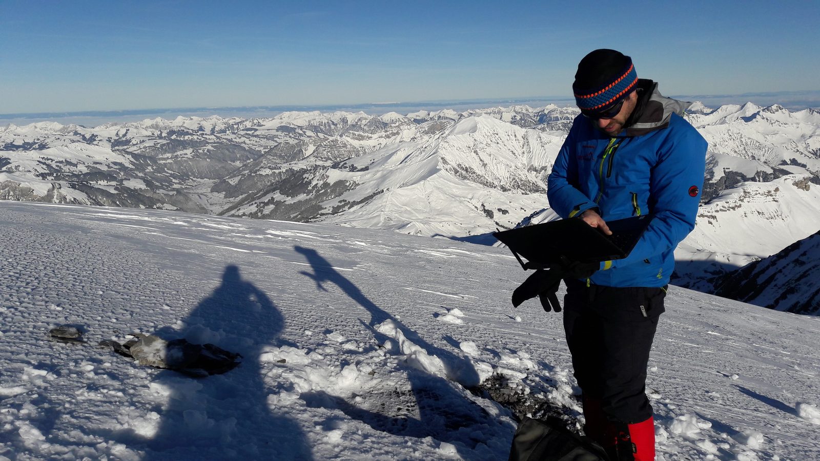 Techniker mit Laptop am Wildstrubel, Sensor-Service über den Schweizer Alpen
