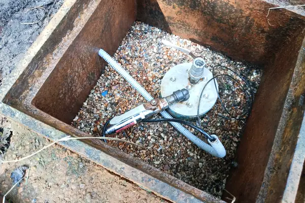 Sensorinstallation in geöffnetem Stahlkasten auf Kiesbett, Edelstahlplatte mit Kabelverschraubung